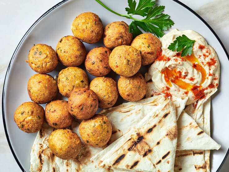 Frittierte Topinambur-Bällchen mit Hummus und Fladenbrot.