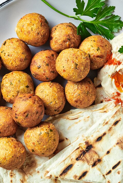 Frittierte Topinambur-Bällchen mit Hummus und Fladenbrot.