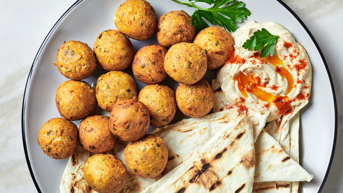 Frittierte Topinambur-Bällchen mit Hummus und Fladenbrot.
