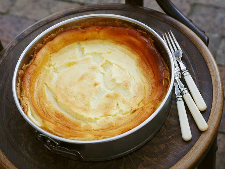 Frisch gebackener Käsekuchen mit goldener Oberfläche in einer Springform. 