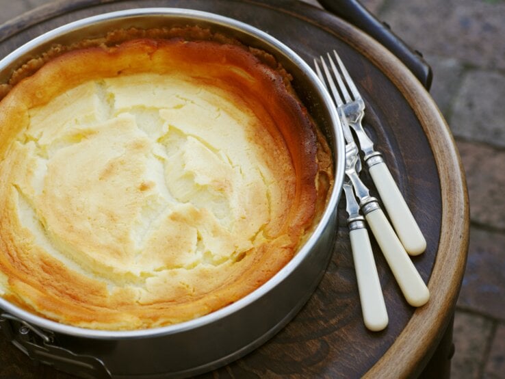 Frisch gebackener Käsekuchen mit goldener Oberfläche in einer Springform. 