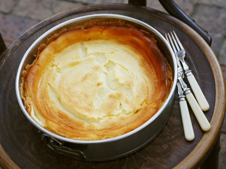 Frisch gebackener Käsekuchen mit goldener Oberfläche in einer Springform. 