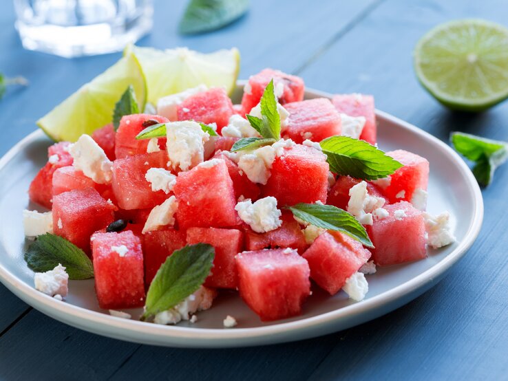 Melone-Feta-Salat Ein Melonen-Feta-Salat auf einem Teller, stehen auf einem Tisch ist zu sehen.