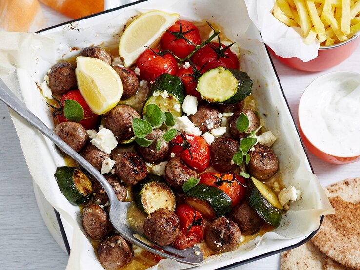 Eine quadratische weiße Ofenform mit dem Gericht auf einem hellen Tisch direkt von oben fotografiert.