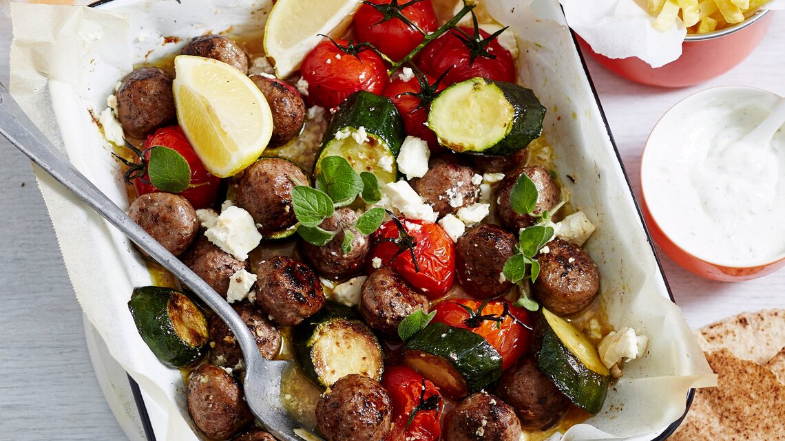 Eine quadratische weiße Ofenform mit dem Gericht auf einem hellen Tisch direkt von oben fotografiert.