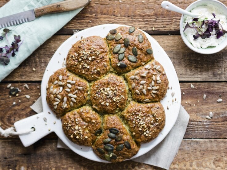 Low-Carb-Brötchen Brötchensonne auf rustikalem Holztisch von oben fotografiert.