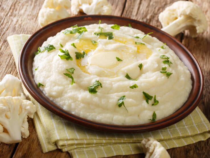 Low-Carb-Blumenkohlpüree braune Schale mit Blumenkohlpüree auf Holztisch.