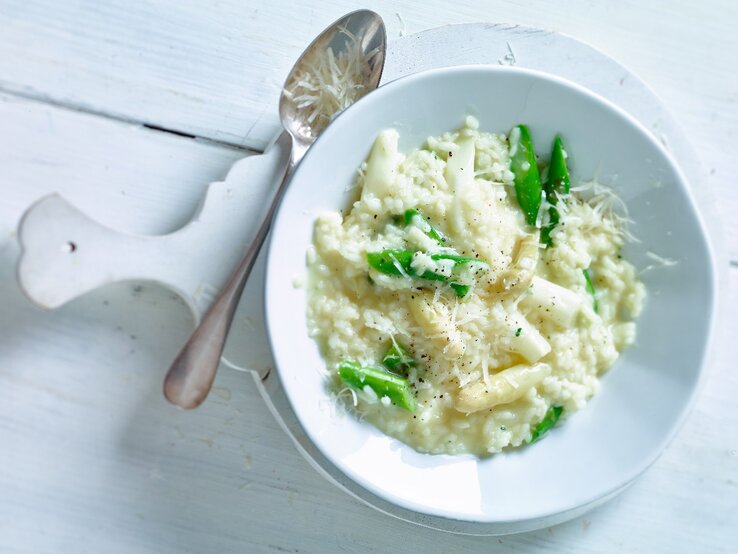 Cremiges Risotto mit grünem und weißem Spargel auf einem Teller.