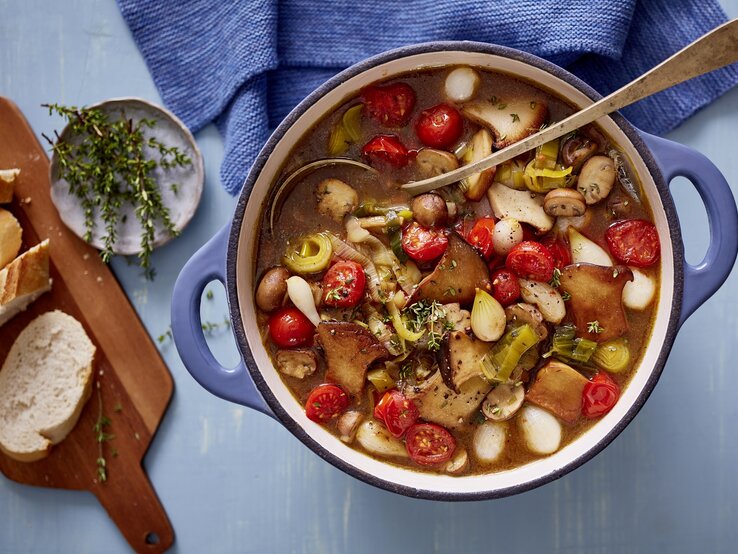 Pilzgulasch! Pilzgulasch in rundem Topf, darin eine Suppenkelle.