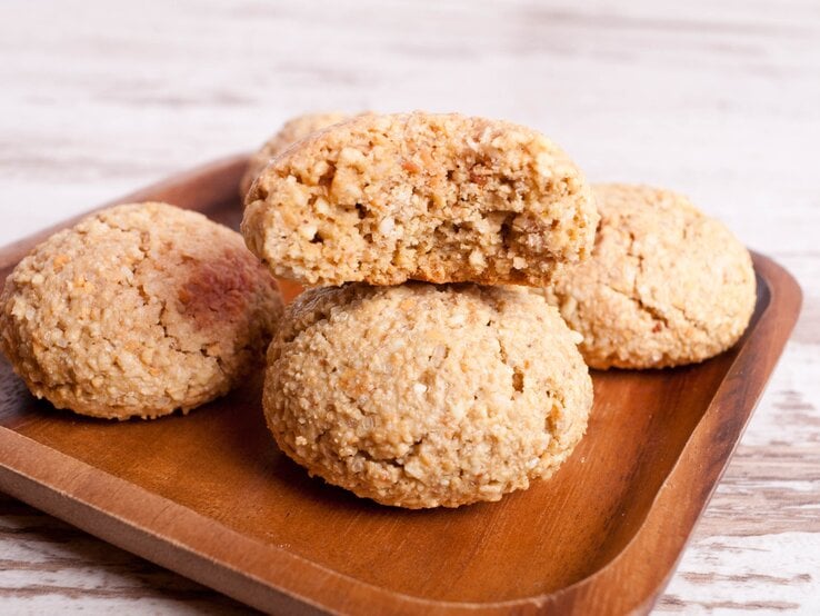 Gebackene Kokoskekse auf Holzteller.