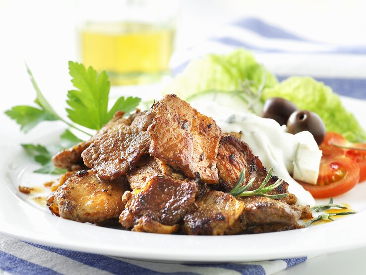 Weißer Teller, darauf angerichtet Gyros und Tzaziki.