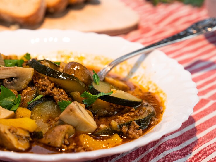 Bauerntopf Weißer Teller gefüllt mit Bauerntopf mit Zucchini und Hackfleisch.