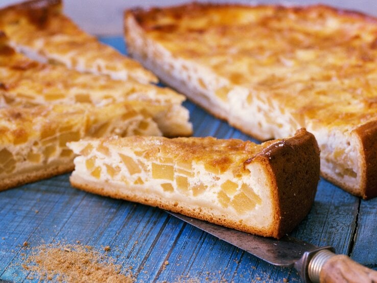 Einige Stücken vom hesssischen Schmandkuchen auf einem blauen Holztisch.