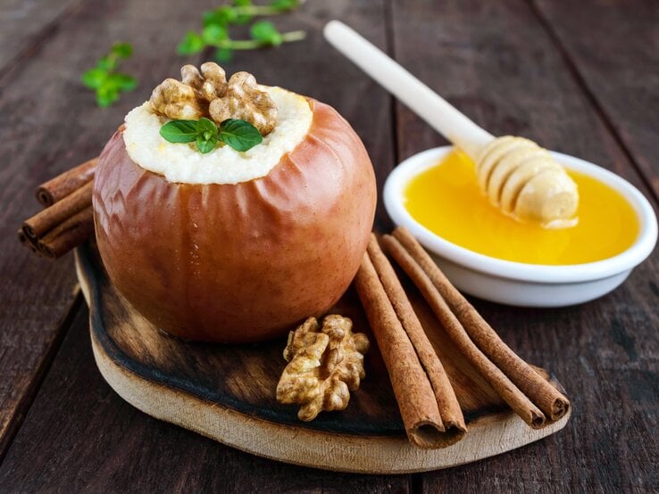 Bratapfel-Mousse mit Vanillesoße in einem Bratapfel / Zimstangen / Walnusskerne