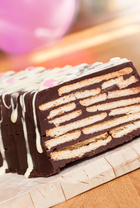 Ein angeschnittener Kalter Hund auf Holzbrett.