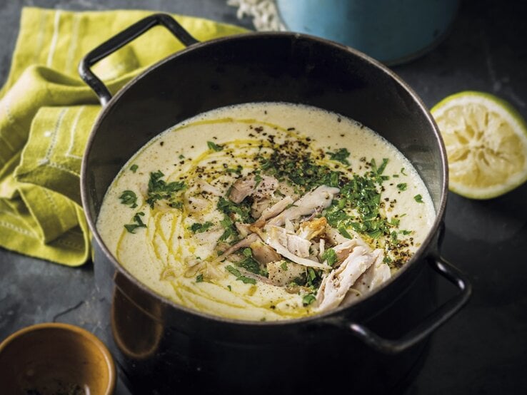 Super lecker: die griechische Hühnersuppe Kotosoupa Avgolemono. Griechische Hühnersuppe mit Zitrone und Reis in einem Topf/ Draufsicht, schräg