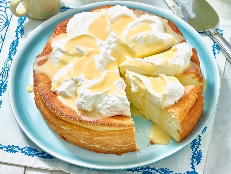 Der Eierlikör-Käsekuchen von schräg oben auf einem hellblauen Teller fotografiert.