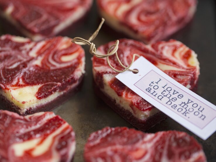 Kleine, herzig ausgestochene Marmorierte Mini-Käsekuchen mit einem rot-weißen Muster auf einer Servierplatte.