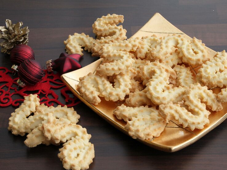 Ein Teller belegt mit mehreren Spritzgebäck-Plätzchen. 