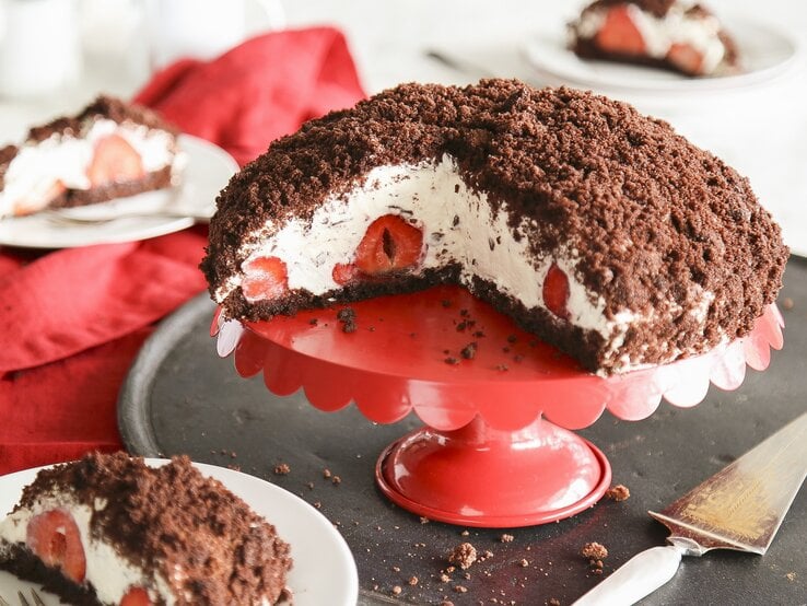 angeschnittener Maulwurfkuchen mit Erdbeeren auf einer Etagere. 