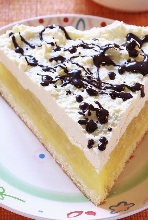 Der Apfelkuchen auf einem bunten Teller mit Schokosoße.