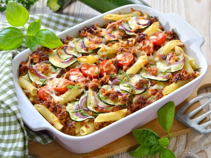 Weiße Auflaufform gefüllt mit traditioneller Penne al forno – lecker mit Hack und Zucchini!