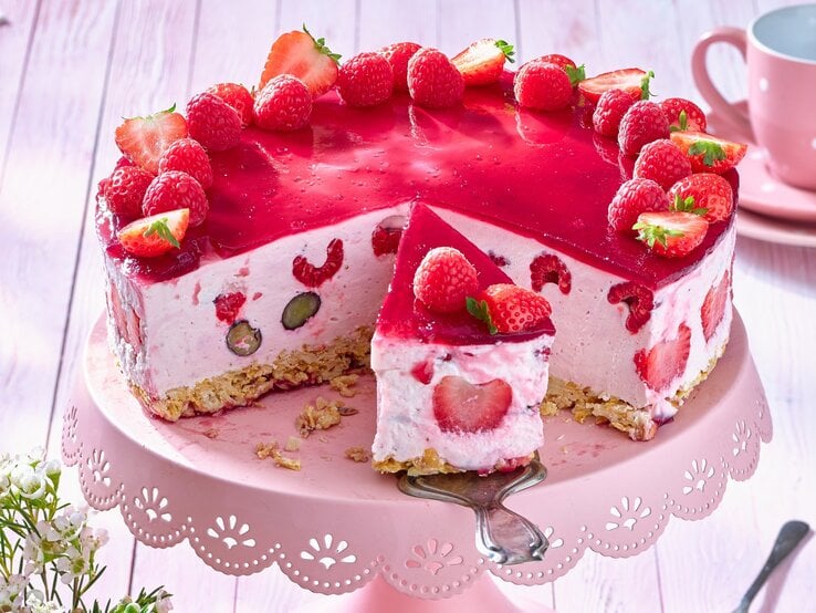 Beeren-Quark-Torte auf einem rosa Tortenteller. 