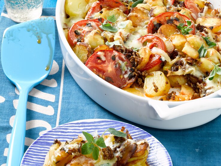 Bratkartoffel-Hack-Auflauf mit Tomaten und Gewürzen / Draufsicht schräg / Tellerrand / Kochlöffel