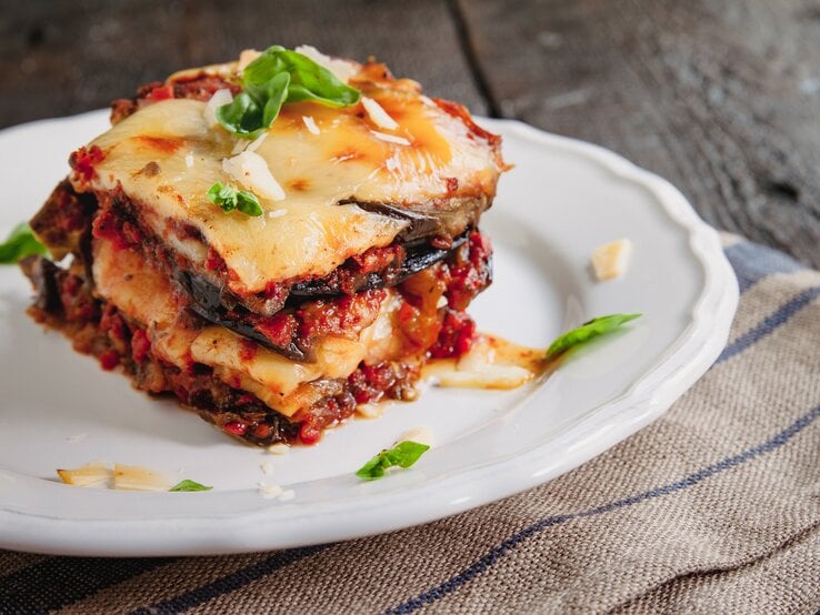 Parmigiana di Melanzane auf einem weißen Teller. 