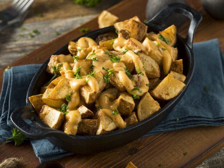 Patatas bravas mit Soße in schwarzer Schale.