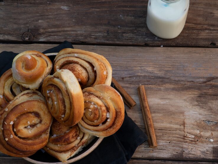 Kanelbullar Mehrere schwedische Zimtschnecken in rustikalem Ambiente.