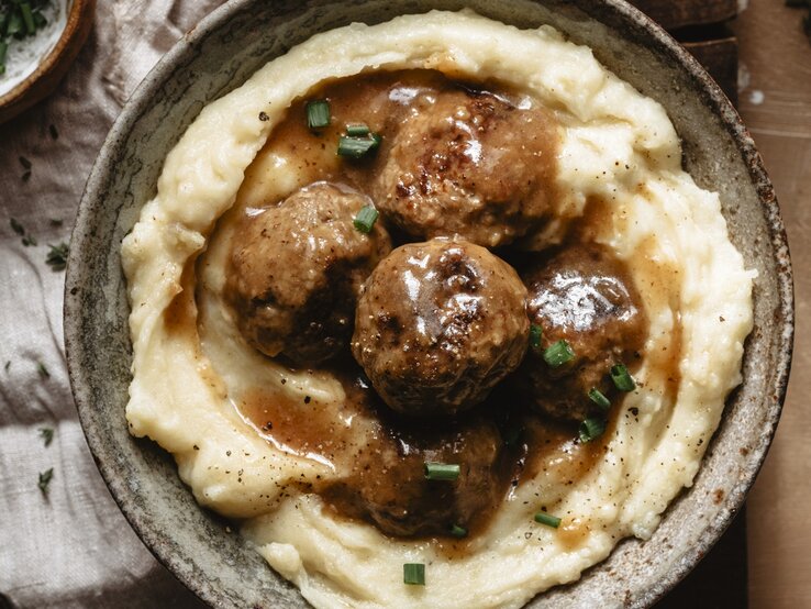 Mehrere Hackbällchen auf Kartoffelpüree / runde Schüssel / Draufsicht