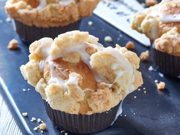 Muffins mit Streuseln auf einem blauen Untergrund.