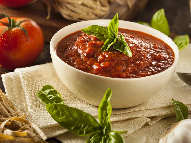 Tomatensoße in weißer Schale in mediterranem Ambiente. 