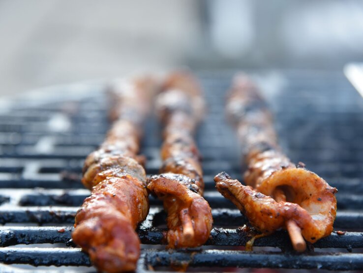 Grillfackeln-Paprikamarinade Selbst gemachte Grillfackeln mit Paprikamarinade beim Grillen auf einem Grillrost. Außenaufnahme. Frontalansicht.