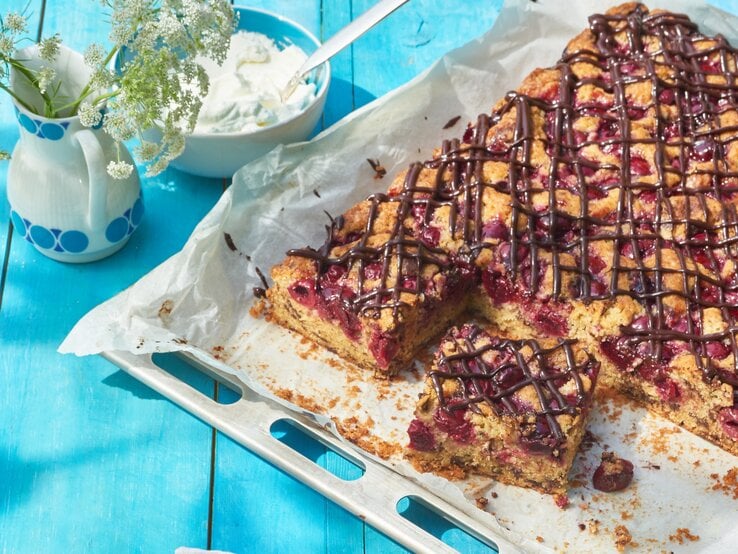 Kirschkuchen mit Schokochips vom Blech / Vase mit Blumen / Schale mit Sahne