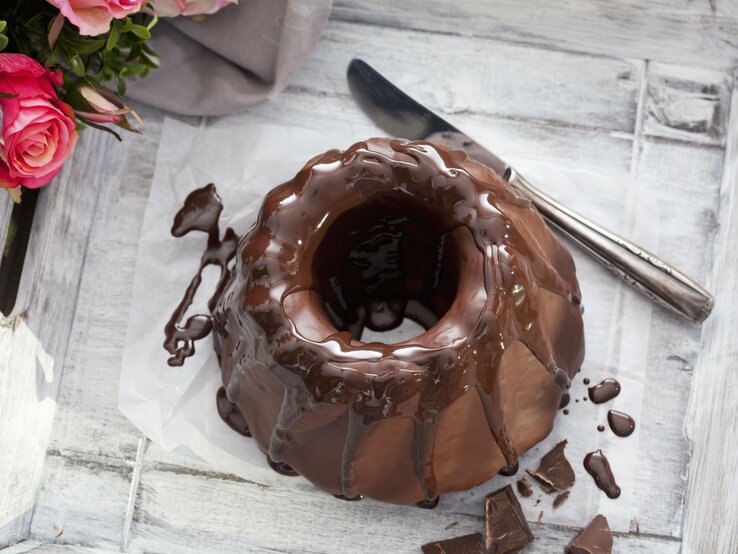 Ein Schokoladen-Kuchen von oben auf einem grauen Tisch fotografiert.