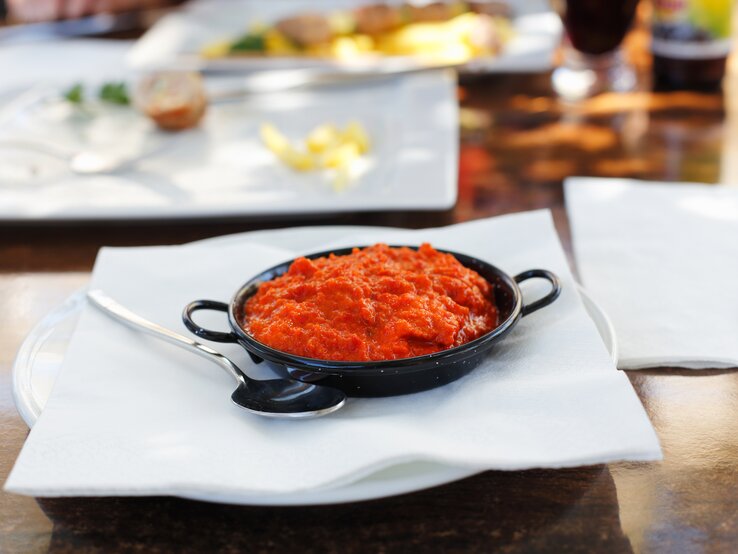 Schwarze Schale gefüllt mit klassischem Ajvar.