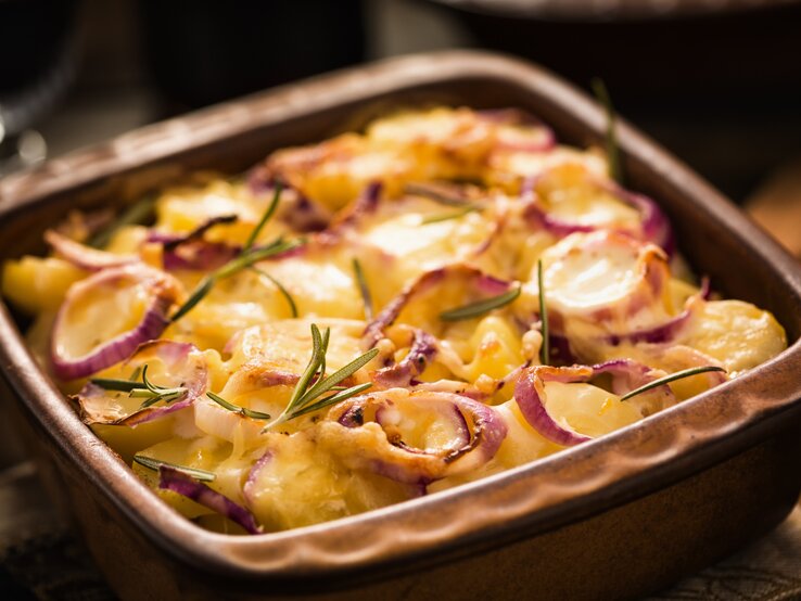 Das Kartoffelgratin mit Hackfleisch auf einem Holztisch.