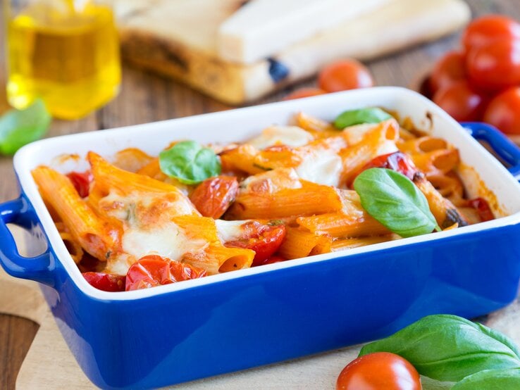 blaue Auflaufform gefüllt mit Tomate-Mozzarella-Auflauf. 