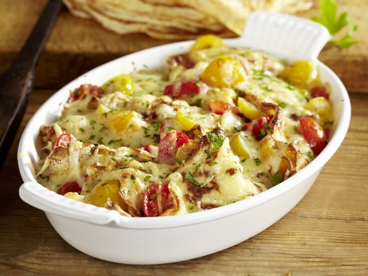 Der Schweizer Auflauf Sittertobelmahl in einer ovalen Form. Untergrund Holz / Draufsicht, leicht schräg von oben.