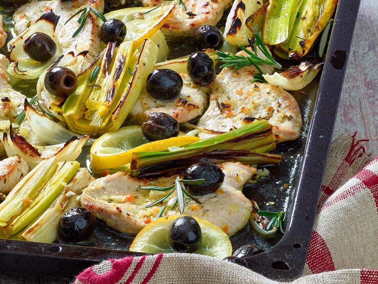 Zitronenschnitzel mit Fenchel Zarte Hähnchenfilets mit schwarzen Oliven, Lauch, Fenchel, Zitrone und Rosmarin auf einem Blech goldbraun gebacken.