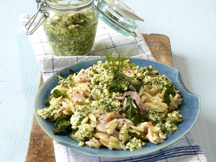 Feta-Dill-Pesto mit Orzo-Nudeln auf einem blauen Teller. 