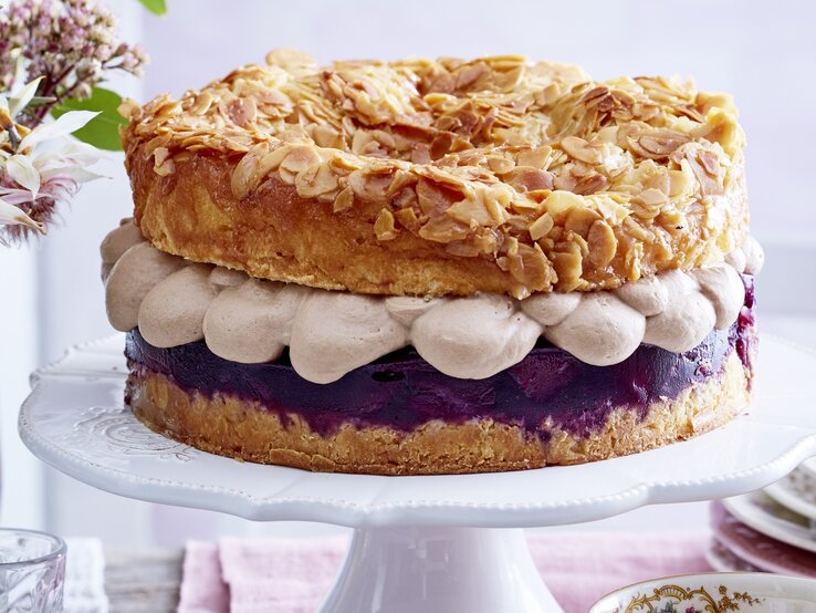 Bienenstich mit einem Rotwein-Birnenkompott Frontal fotografierter Bienenstich mit Nougatsahne und Rotwein-Birnenkompott auf einer Etagere.