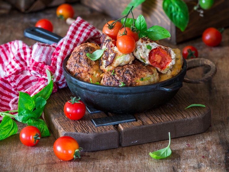  Hühnerhackbällchen mit Kirschtomaten in ofenfester Form / Nahaufnahme / Frontalsicht