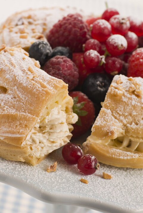 Seitliche Ansicht eines Paris Brest Kuchens, garniert mit Beeren.