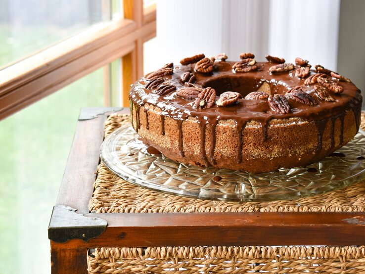 seitliche Ansicht auf einen runden Kuchen mit Glasur und Nüssen. 