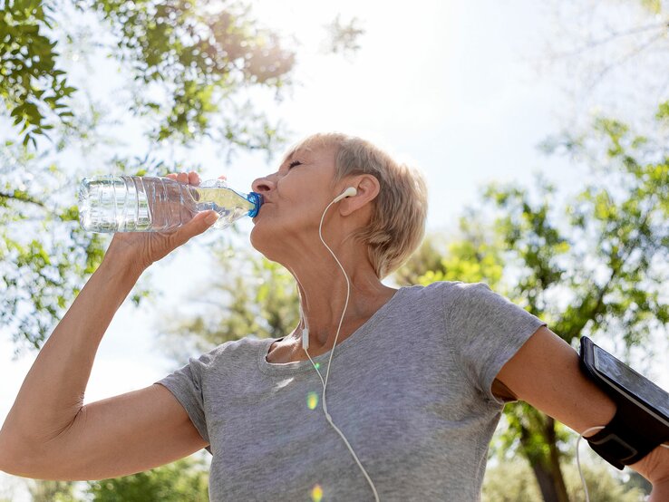 Bindegewebe-straffen-Wasser-trinken | © iStock/Nastasic Frau trinkt aus Wasserflasche beim Sport | © iStock/Nastasic