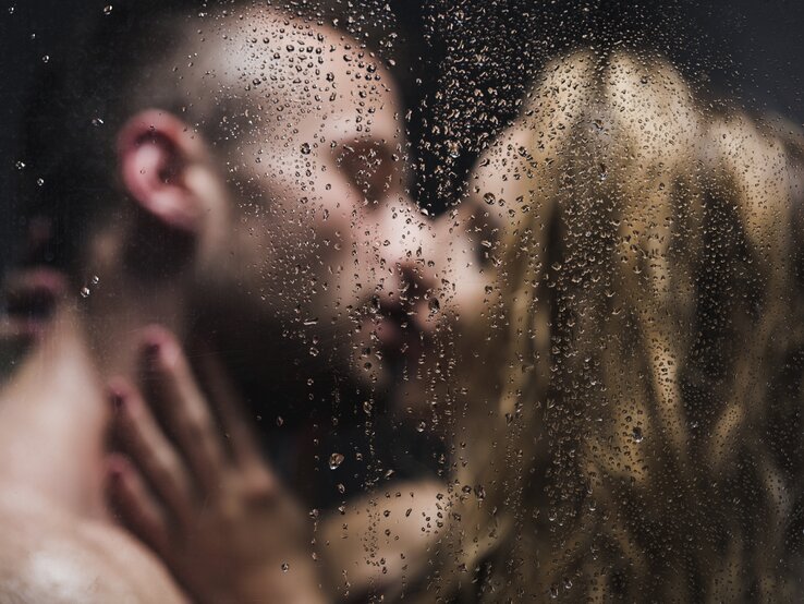 Ein küssendes Paar, das unter der Dusche steht