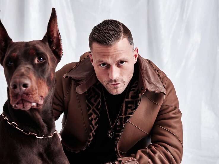 Rapper Kontra K  mit einem Hund an seiner Seite